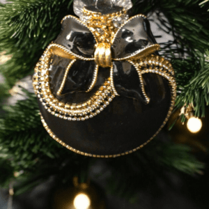 Black and gold Christmas ornament displayed on a shelf